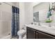 Well-lit bathroom featuring a shower with blue patterned curtain, a sink and a dark wood vanity at 149 Cribbs Ln, Middlesex, NC 27557