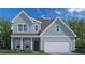 Charming two-story home with blue siding, a two-car garage, and a well-maintained front yard with flower beds at 149 Cribbs Ln, Middlesex, NC 27557