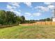 Fenced backyard with lush green grass with wooded area at the far end at 155 Jade St, Smithfield, NC 27577