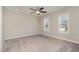 A sunlit bedroom featuring neutral carpet and paint, a ceiling fan and two windows at 155 Jade St, Smithfield, NC 27577