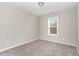 A sunlit bedroom featuring neutral carpet and paint, and a window at 155 Jade St, Smithfield, NC 27577