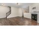 Open-concept living room with hardwood floors, staircase and a cozy fireplace at 155 Jade St, Smithfield, NC 27577