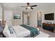 Well-furnished main bedroom with a television, a ceiling fan, and a door to the bathroom at 155 Jade St, Smithfield, NC 27577