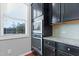 Well-lit kitchen with stainless steel built-in microwave and oven, granite countertops, and dark wood cabinetry at 1600 Tinos Overlook Way, Apex, NC 27502