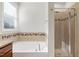 Bright bathroom featuring a soaking tub, tiled shower, and decorative tile accents at 1707 Capstone Dr, Durham, NC 27713