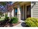 Charming entrance featuring a brick pillar, well-maintained landscaping, and a stylish, paneled front door at 1707 Capstone Dr, Durham, NC 27713