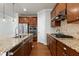 A close up of a kitchen island with a stainless steel sink, granite countertops, and brown wood cabinets at 1707 Capstone Dr, Durham, NC 27713
