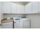 Convenient laundry room equipped with modern appliances and ample cabinet space at 1707 Capstone Dr, Durham, NC 27713