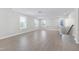 Spacious living room featuring wood-look floors, natural light from multiple windows, and access to stairs at 1707 Capstone Dr, Durham, NC 27713