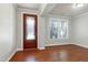 Inviting living room with rich hardwood floors, natural light, and a stylish front door at 1707 Capstone Dr, Durham, NC 27713