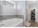 Relaxing bathroom with a large tub and a separate glass-enclosed shower next to the walk-in closet at 192 Kensington Dr, Spring Lake, NC 28390