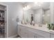 Bright bathroom featuring double sinks, a large mirror, and a glimpse into the walk-in closet, offering ample space at 192 Kensington Dr, Spring Lake, NC 28390