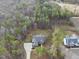 Aerial view of a beautiful home nestled in a wooded area with a long driveway and well-manicured lawn at 20 Crane Dr, Louisburg, NC 27549