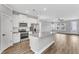 Open-concept kitchen with stainless steel appliances, granite counters, and a large center island at 204 Jetson Creek Way, Youngsville, NC 27596