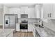 Modern kitchen features stainless steel appliances, granite countertops, and white cabinetry at 208 Brickwell Way, Youngsville, NC 27596