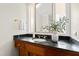 Bathroom vanity featuring a dark countertop, wooden cabinets, an oval sink and an ornate mirror at 2147 Wake Dr, Raleigh, NC 27608
