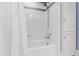 Clean bathroom with a bathtub, shower, tiled walls, and storage cabinet at 2147 Wake Dr, Raleigh, NC 27608
