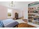 Bedroom with hardwood floors and pink walls featuring a bed, bookcase, and window at 2147 Wake Dr, Raleigh, NC 27608