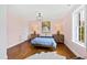 Bedroom with hardwood floors and pink walls featuring a bed, side tables, and lamps at 2147 Wake Dr, Raleigh, NC 27608