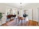 Elegant dining room featuring modern lighting and clear chairs, with an adjacent view of the living room at 2147 Wake Dr, Raleigh, NC 27608