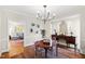 Elegant dining room with hardwood floors, stylish chandelier, and a view into the adjacent living area at 2147 Wake Dr, Raleigh, NC 27608