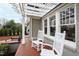 Inviting covered front porch showcasing white rocking chairs, brick flooring, and architectural details, perfect for relaxing at 2147 Wake Dr, Raleigh, NC 27608