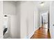 Hallway with hardwood floors and neutral paint featuring views into other rooms at 2147 Wake Dr, Raleigh, NC 27608