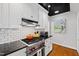 White kitchen with stainless steel appliances, black countertops and a view of the backyard at 2147 Wake Dr, Raleigh, NC 27608