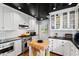 Bright kitchen with stainless steel appliances, white cabinets, black countertops, and hardwood floors at 2147 Wake Dr, Raleigh, NC 27608