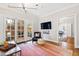 Bright sitting room features hardwood floors, french doors, and stylish décor; open to dining area at 2147 Wake Dr, Raleigh, NC 27608
