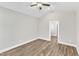 A gray toned bedroom is bright with light colored vinyl flooring and a ceiling fan and light fixture at 305 Brickwell Way, Youngsville, NC 27596