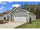Charming single-Gathering home featuring a two-car garage, light green vinyl siding, and a well-maintained front yard at 305 Brickwell Way, Youngsville, NC 27596