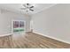 Spacious main bedroom featuring a ceiling fan, sliding glass door, vinyl plank flooring, and natural light at 305 Brickwell Way, Youngsville, NC 27596