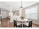 Bright dining room with a round table, four chairs, hardwood floors, and view into the living room at 4511 All Points View Way, Raleigh, NC 27614