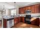 Modern kitchen featuring stainless steel appliances, granite countertops, and dark wood cabinets at 4511 All Points View Way, Raleigh, NC 27614
