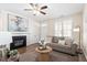 Cozy living room with fireplace, hardwood floors, gray sofa, and a decorative ceiling fan at 4511 All Points View Way, Raleigh, NC 27614
