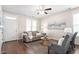 Comfortable living room with hardwood floors, gray sofa, ceiling fan, and abundant natural light at 4511 All Points View Way, Raleigh, NC 27614