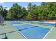 Community tennis courts with blue and green surface and surrounded by trees at 4511 All Points View Way, Raleigh, NC 27614
