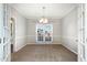 Bright dining room with carpet, white trim, a modern light fixture, and window views at 5302 Silkwood Dr, Durham, NC 27713