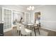 Staged dining room with carpet, white trim, chandelier, and french door access to other rooms at 5302 Silkwood Dr, Durham, NC 27713