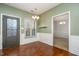 Dining area with decorative door, chandelier lighting, wainscoting, and hardwood floors at 5302 Silkwood Dr, Durham, NC 27713