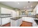 Bright kitchen with white cabinets, granite countertops, and an island, open to the dining at 5302 Silkwood Dr, Durham, NC 27713