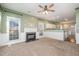 Spacious living room featuring a cozy fireplace, large windows, and an open floor plan to the kitchen at 5302 Silkwood Dr, Durham, NC 27713