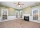 Spacious living room featuring a cozy fireplace, large windows, and an open floor plan to the kitchen at 5302 Silkwood Dr, Durham, NC 27713