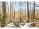 The house features a back deck ideal for relaxing outdoors with a glass table and chairs at 577 Woodbury, Pittsboro, NC 27312