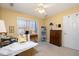 Bright yellow bedroom features a ceiling fan, sewing station, and natural light streaming through a window at 577 Woodbury, Pittsboro, NC 27312