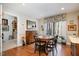 Cozy dining room features a round table, hardwood floors, and natural light from a window with floral valance at 577 Woodbury, Pittsboro, NC 27312