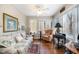 Cozy sunroom features multiple windows, natural light, and comfortable seating with floral-patterned sofa and chair at 577 Woodbury, Pittsboro, NC 27312