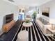 Bright living room with modern decor, white sofa and chairs, striped rug, and dark wood floors at 6025 Herston Rd, Raleigh, NC 27610