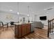 Modern kitchen with a central island, stainless steel appliances, and an open layout to the living area at 729 Colby Pl, Durham, NC 27713